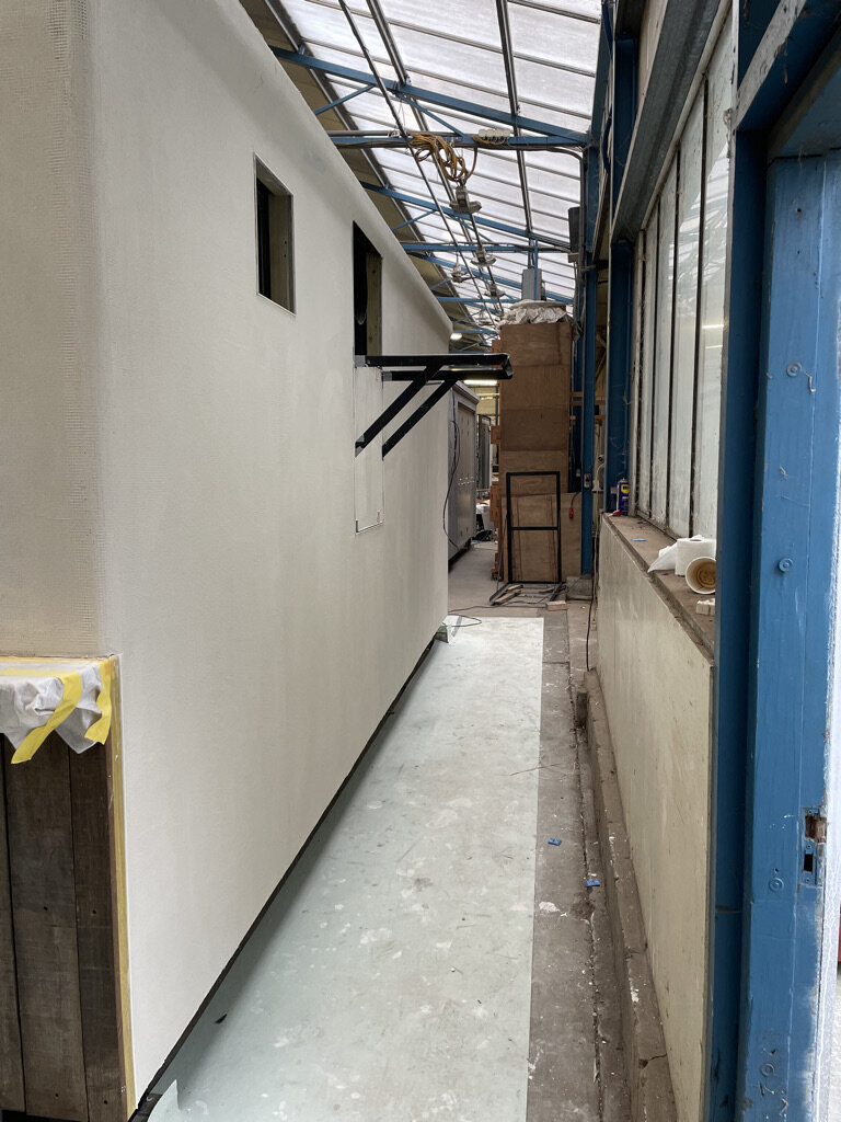 Doorloop in de werkplaats langs de afgewerkte wand