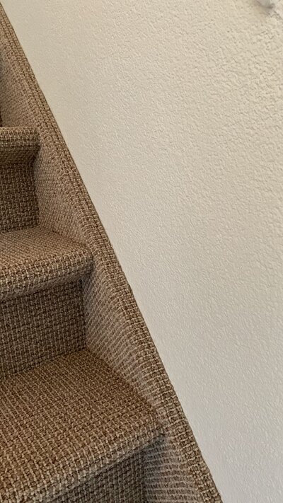 Wand langs een trap met de korrelstructuur van sierpleister
