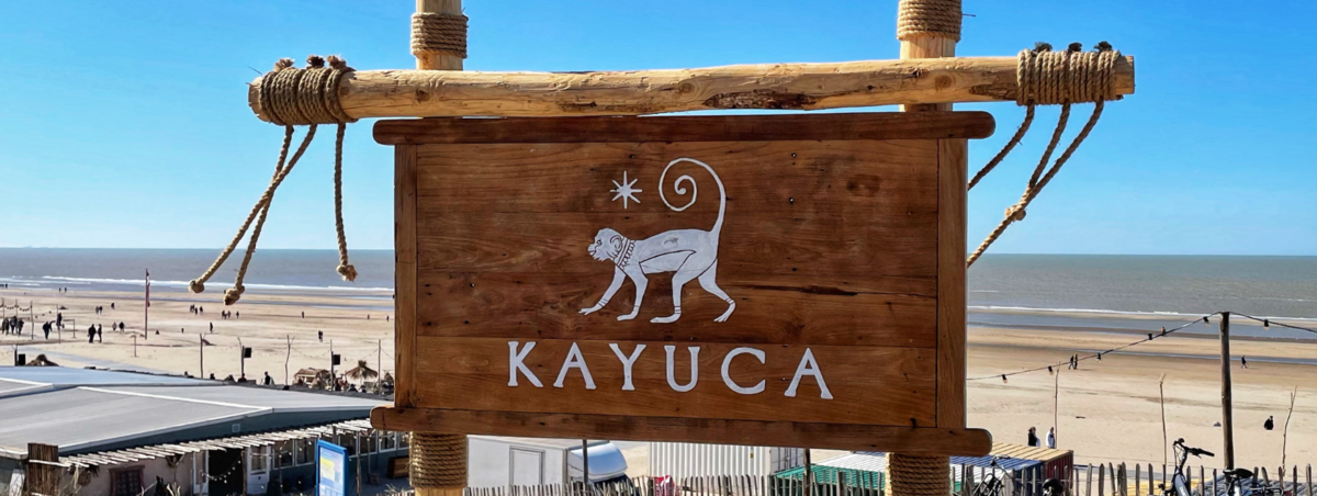 Het houten entreebord van Beachclub KAYUCA aan het strand van Katwijk