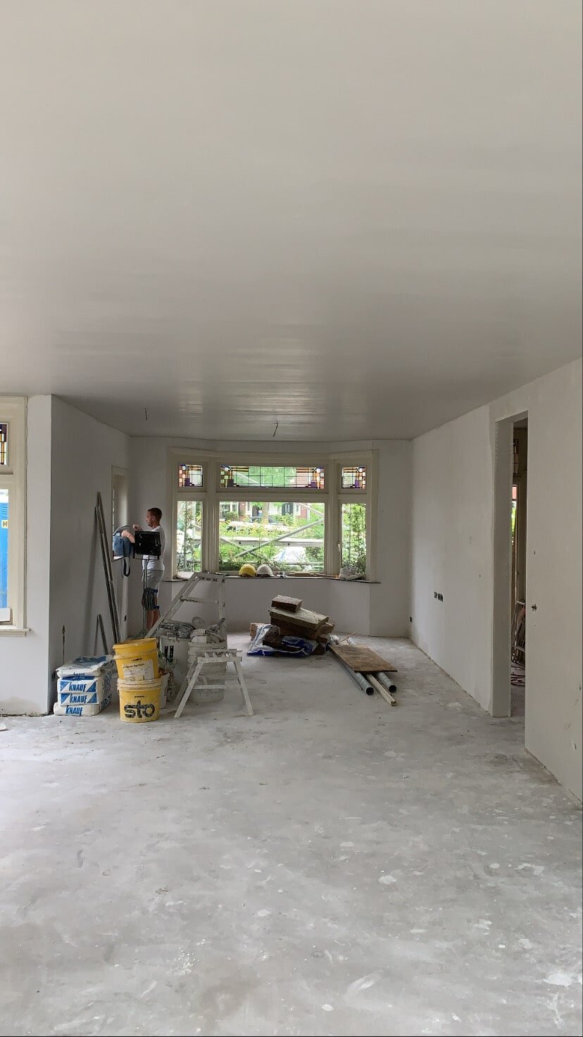 Woonkamer tijdens het werk, wanden en plafond glad afgewerkt